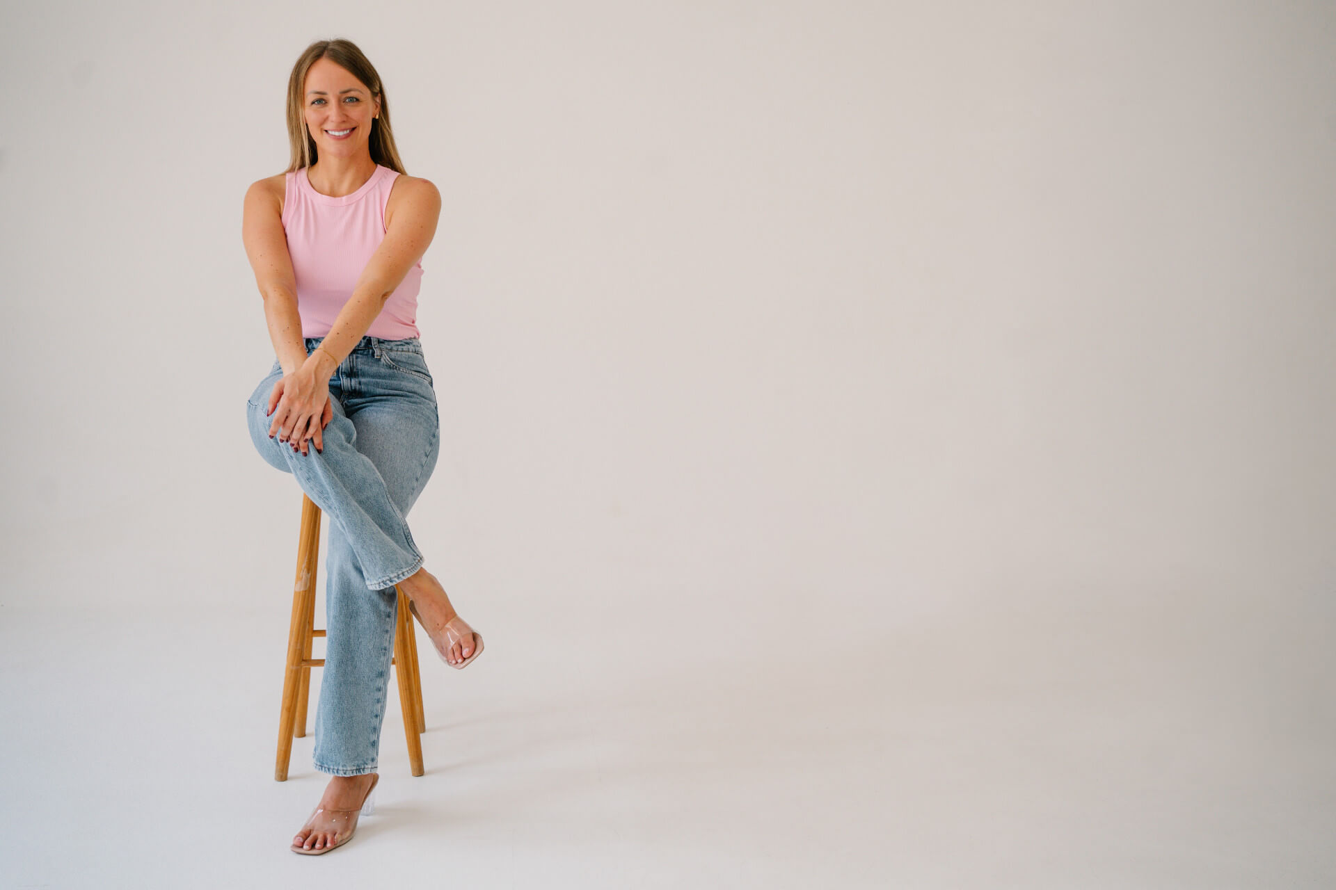 Jennifer sitzend auf Holz Barhocker