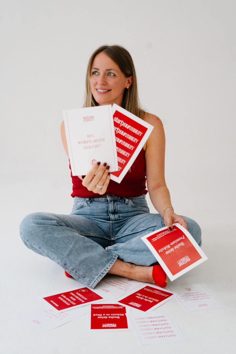 Jennifer sitzt am Boden und hält Schild ‚Website-Bestie gesucht?‘ - Unterstützung für selbstständige Frauen beim Online-Auftritt